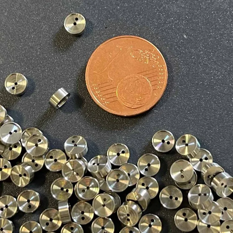 Gedrehte Kleinstteile neben einer 1-Cent-Münze als Größenvergleich